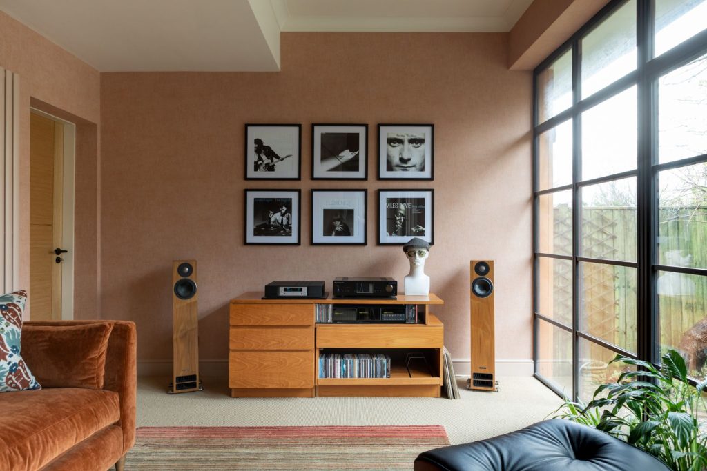 Contemporary listening room with high-end audio system, wooden media unit, floorstanding speakers, framed