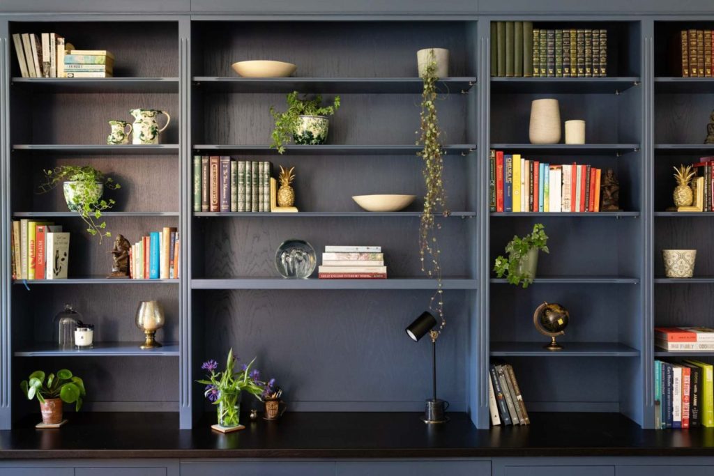 Contemporary workspace with bespoke blue shelving, styled bookcase.